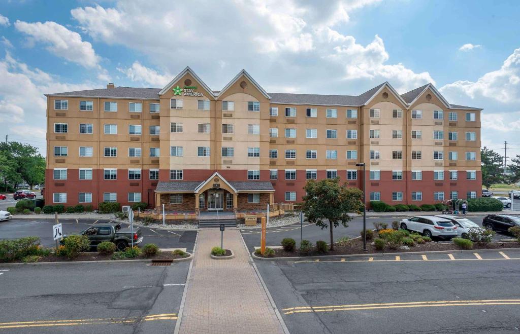 a large building with cars parked in a parking lot at Extended Stay America Suites - Secaucus - New York City Area in Secaucus