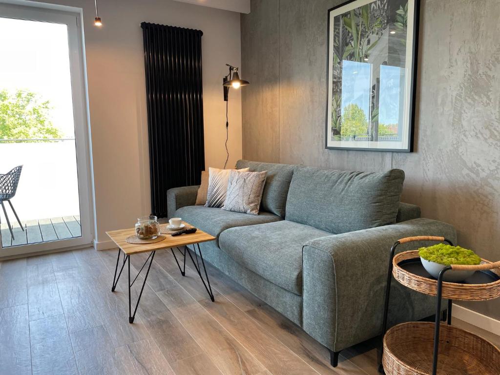 ein Wohnzimmer mit einem Sofa und einem Tisch in der Unterkunft Stylowy Apartament - Port Mielno in Mielno