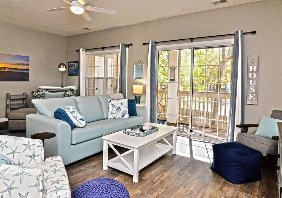 ein Wohnzimmer mit einem Sofa und einem Tisch in der Unterkunft All New Luxury Beach Retreat 1 Mile to Beach w Pool in Myrtle Beach