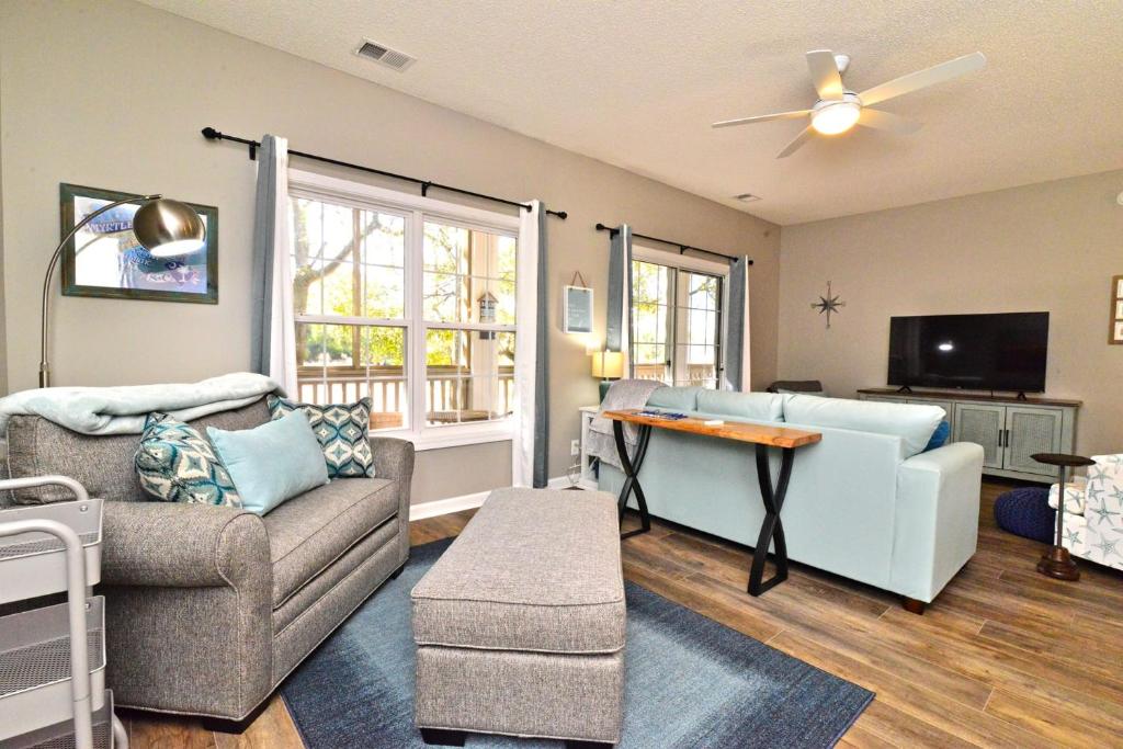 ein Wohnzimmer mit einer Couch und einem Tisch in der Unterkunft All New Luxury Beach Retreat 1 Mile to Beach w Pool in Myrtle Beach