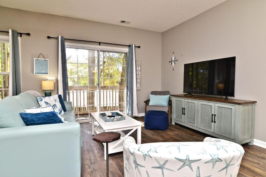ein Wohnzimmer mit Couch und Fernseher in der Unterkunft All New Luxury Beach Retreat 1 Mile to Beach w Pool in Myrtle Beach