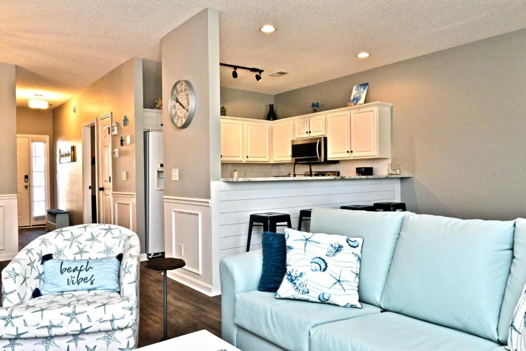 ein Wohnzimmer mit einer blauen Couch und einer Küche in der Unterkunft All New Luxury Beach Retreat 1 Mile to Beach w Pool in Myrtle Beach