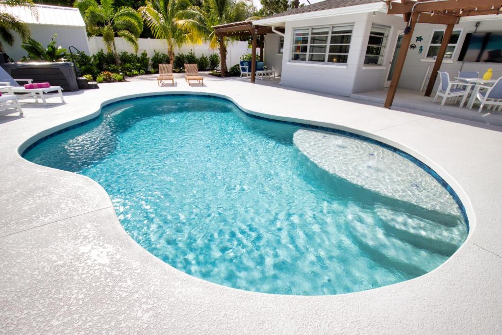 a swimming pool with blue water in a yard at Tropical Oasis, Heated Pool, Hot Tub, Near Siesta Key in Sarasota