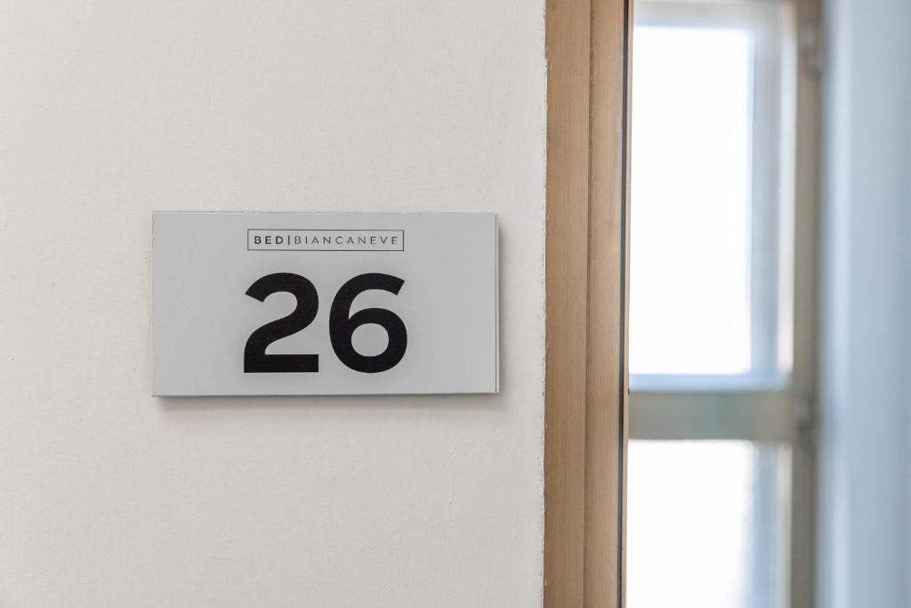 a sign with the number twenty hanging on a wall at BED BIANCANEVE Attico in Villanova di Ostuni