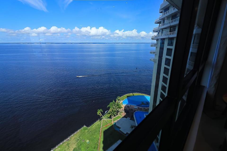 einen Blick auf einen großen Wasserkörper aus einem Gebäude in der Unterkunft Tropical Executive 1307 With View in Manaus