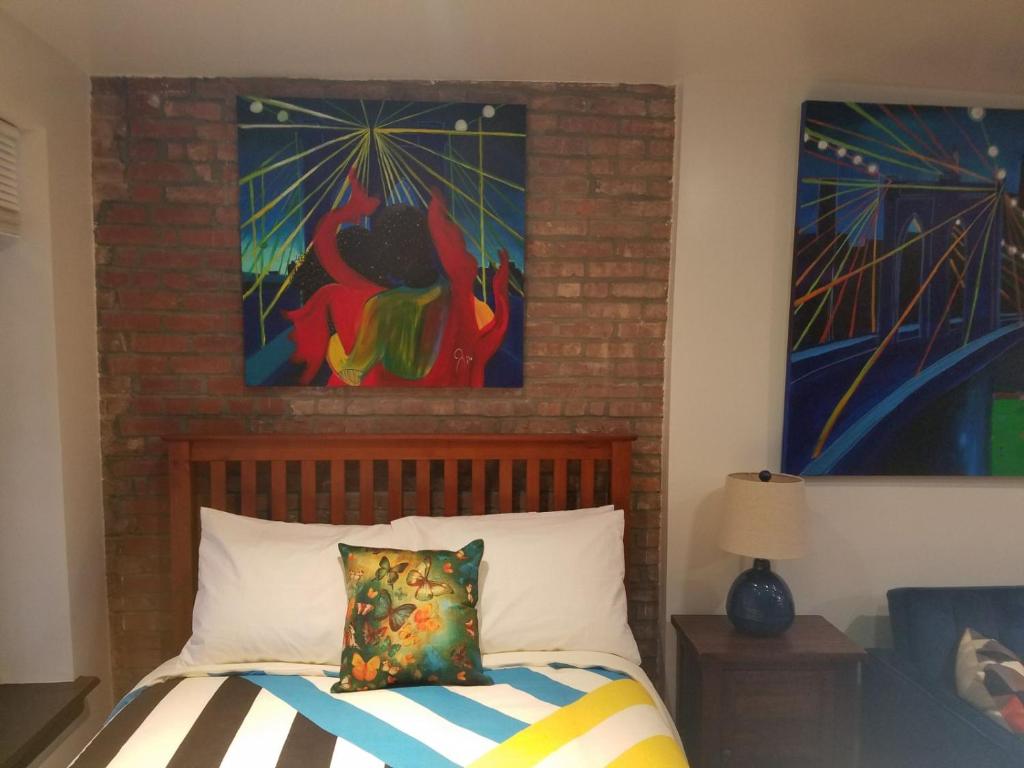 紐約的住宿－The Harlem Getaway，卧室配有一张壁画和两张画的床铺。