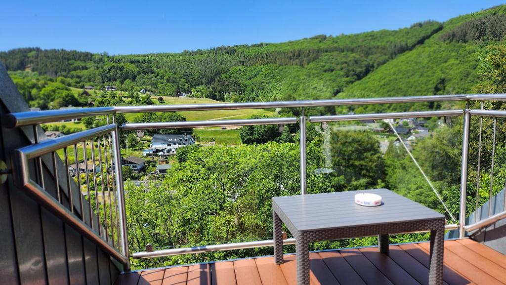 una mesa en un balcón con vistas al valle en Haus Schönblick, en Simmerath