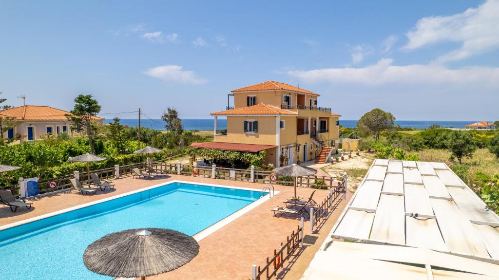 vista sulla piscina in un resort con ombrelloni di Vitoratos Studios a Lixouri