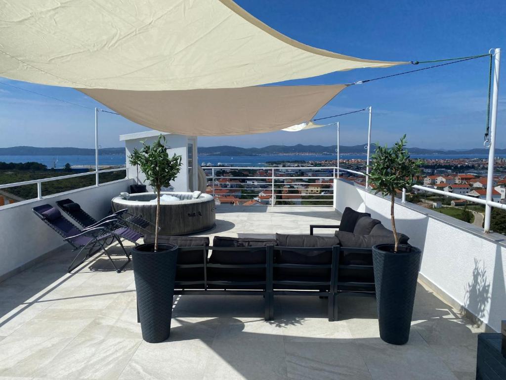 a patio with a couch and a table on a balcony at Wellness Apartments Sunset in Zadar