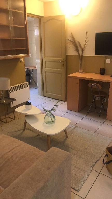 Zimmer mit 2 Tischen und einem Schreibtisch mit einem TV in der Unterkunft MISSYT in Colombes