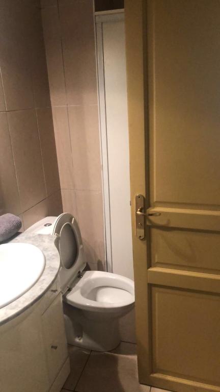 a bathroom with a white toilet and a sink at MISSYT in Colombes
