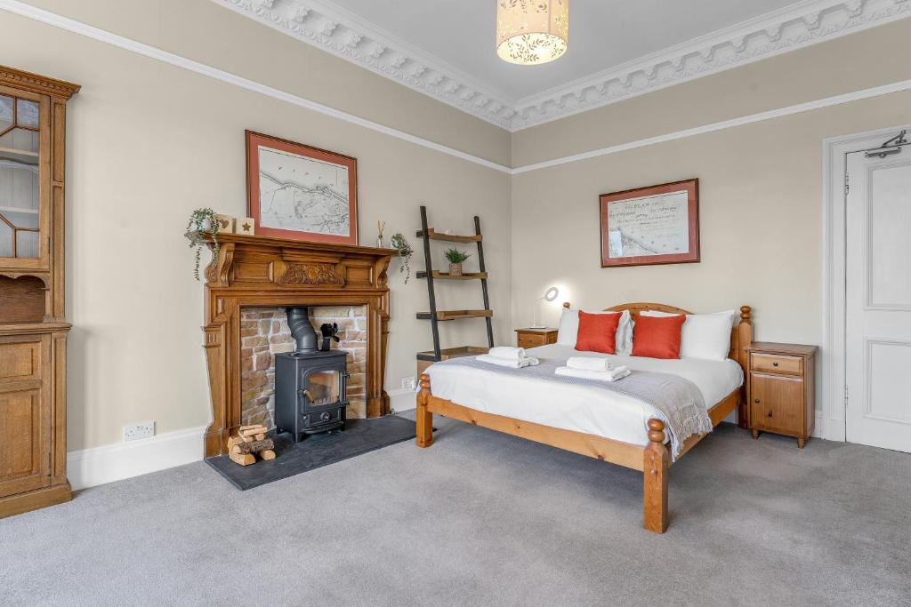 a bedroom with a bed and a fireplace at Marchmont Traditional Apartments in Edinburgh