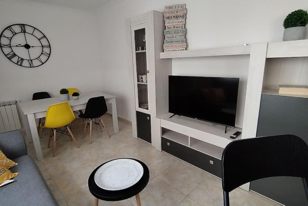 salon z telewizorem, stołem i krzesłami w obiekcie Apartamento en Foz. Primera Línea Playa Rapadoira w mieście Foz