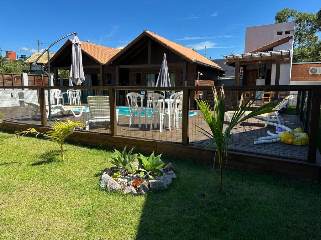 a house with a deck and a swimming pool at POUSADA ROSA e POESIA in Praia do Rosa