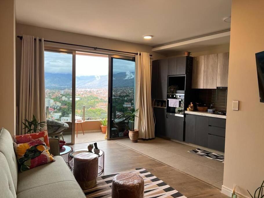 sala de estar con sofá y ventana grande en Depto a estrenar increíble vista 180º Cocha, en Cochabamba