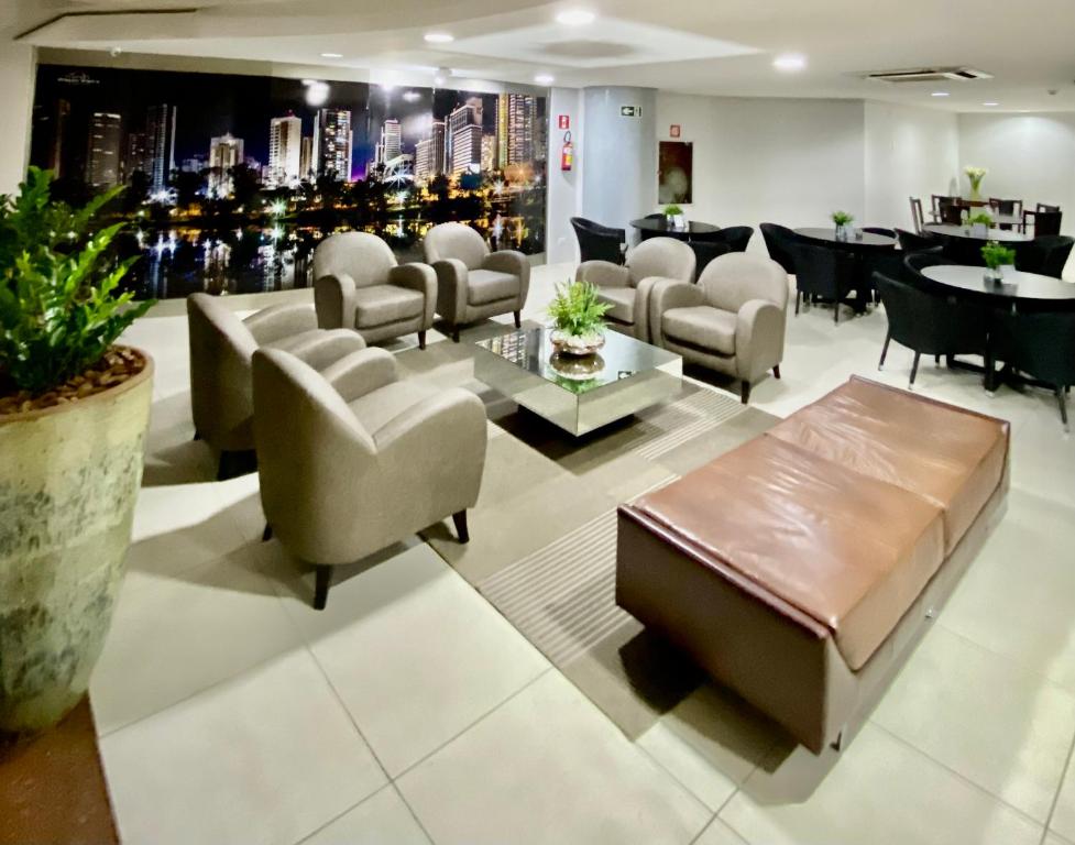 a waiting room with chairs and a couch and tables at Fabulosa Suite 903 em Flat Alto Padrão in Londrina