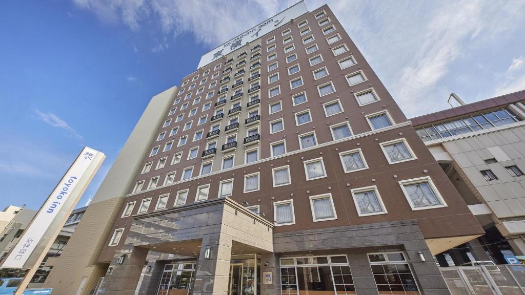 a tall brown building with a building at Toyoko Inn Tokuyama-eki Shinkansen-guchi in Shunan