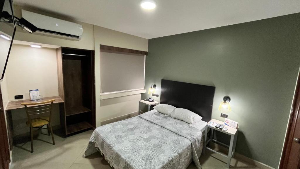 una camera d'albergo con letto, scrivania di Hotel Varadero Internacional a Guayaquil