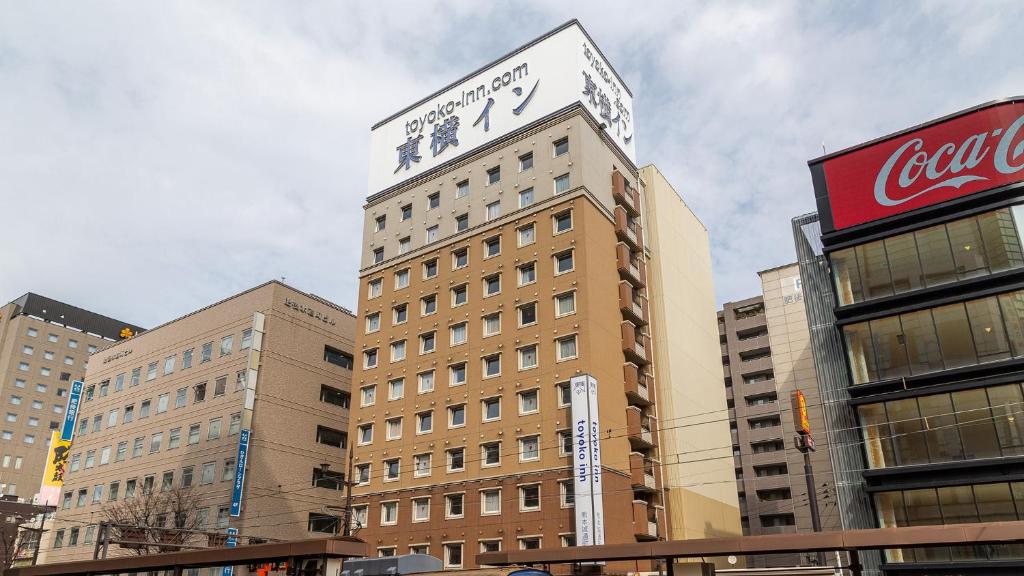 um edifício alto com um relógio em cima em Toyoko Inn Kumamoto-jyo Toricho Suji em Kumamoto