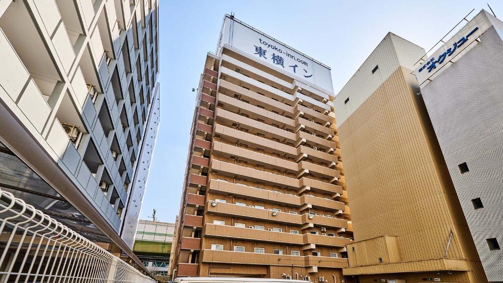 Un grand bâtiment avec un panneau en haut dans l'établissement Toyoko Inn Osaka Umeda Higashi, à Osaka
