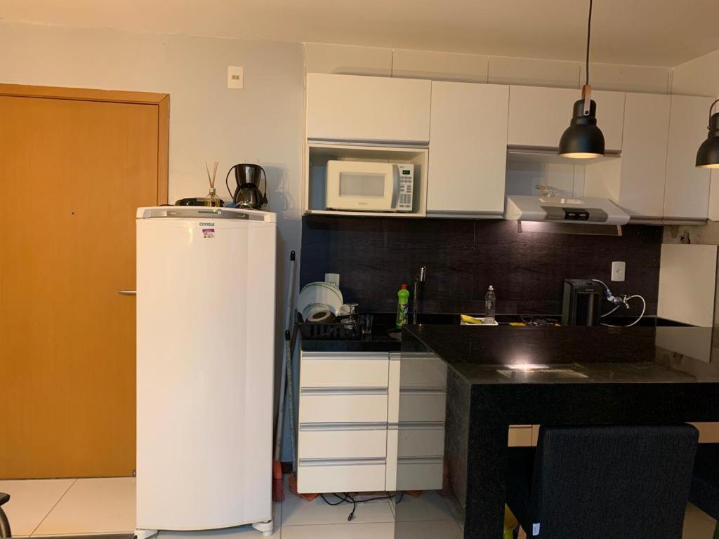 a kitchen with a white refrigerator and a microwave at Aprto luxo ILOA barra de São Miguel in Barra de São Miguel