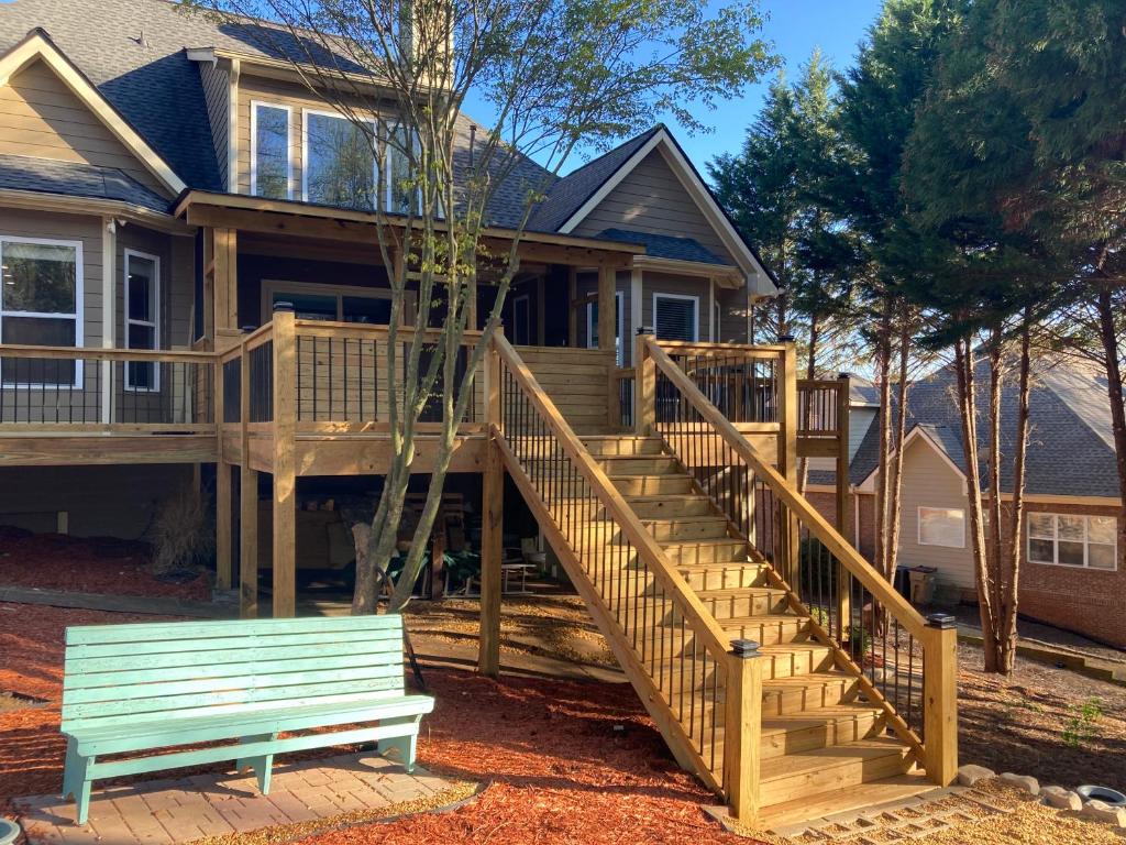 a house with a wooden deck and a bench at Casa Cool in Braselton