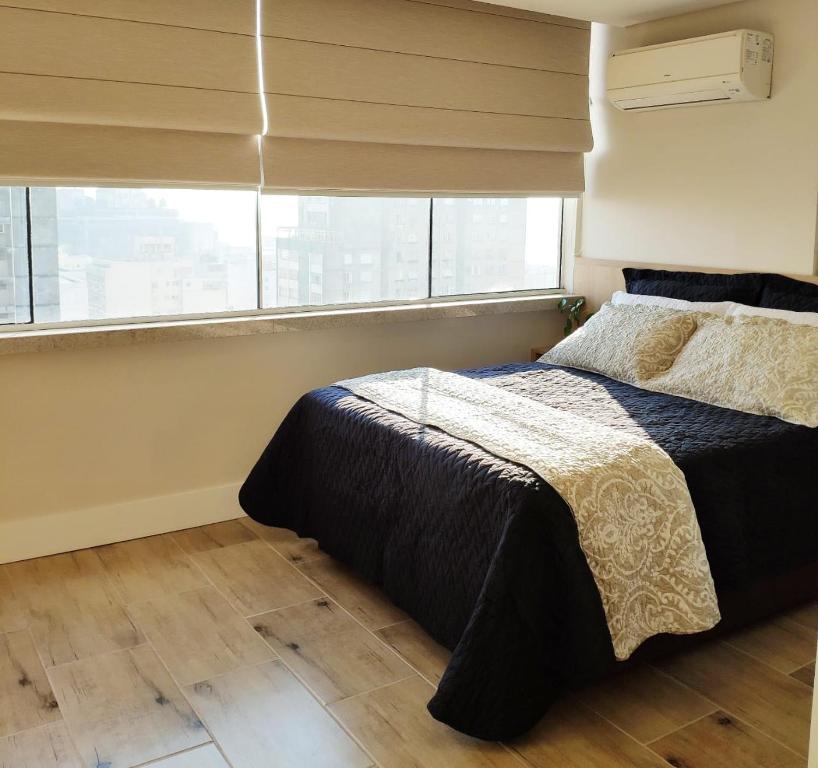 a bedroom with a bed and a window at 20º Andar Vista Linda Próx a Santa Casa, UFRGS - BnB Serviços Inteligentes Por Fioravante in Porto Alegre