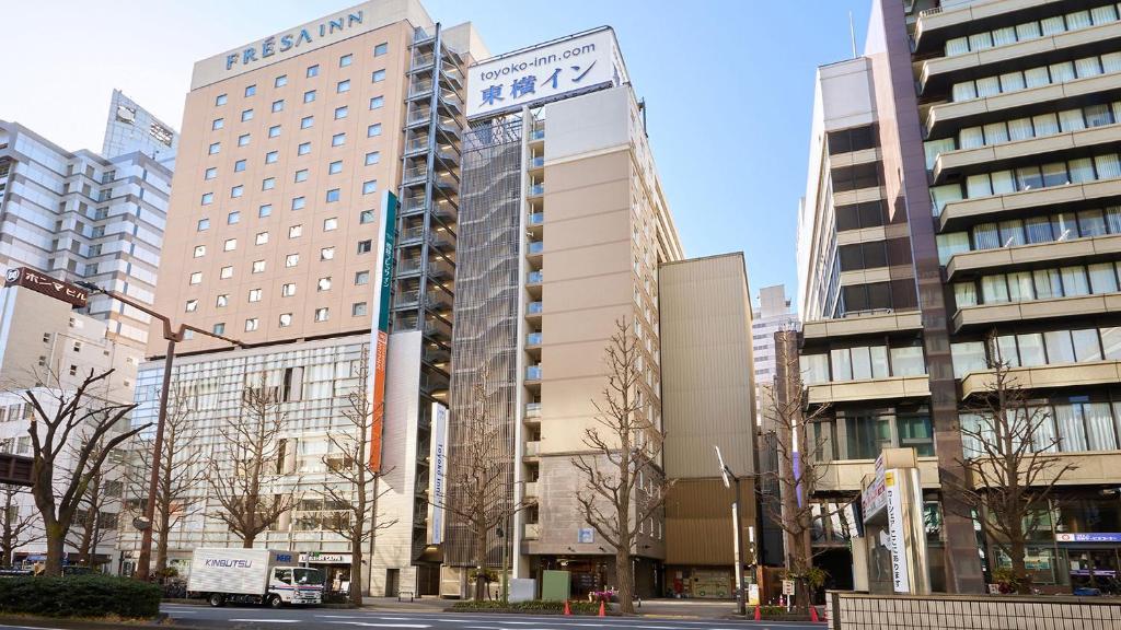 een groep hoge gebouwen in een stad bij Toyoko Inn Kawasaki Ekimae Shiyakusho-dori in Kawasaki