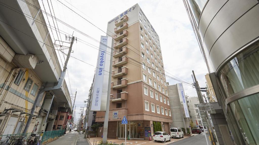 a tall building on a street in a city at Toyoko Inn Musashi-nakahara Ekimae in Kawasaki
