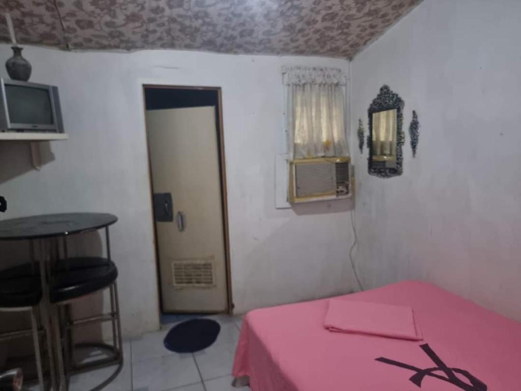 mały pokój z różowym łóżkiem i drzwiami w obiekcie Villa violeta beach resort w mieście San Juan