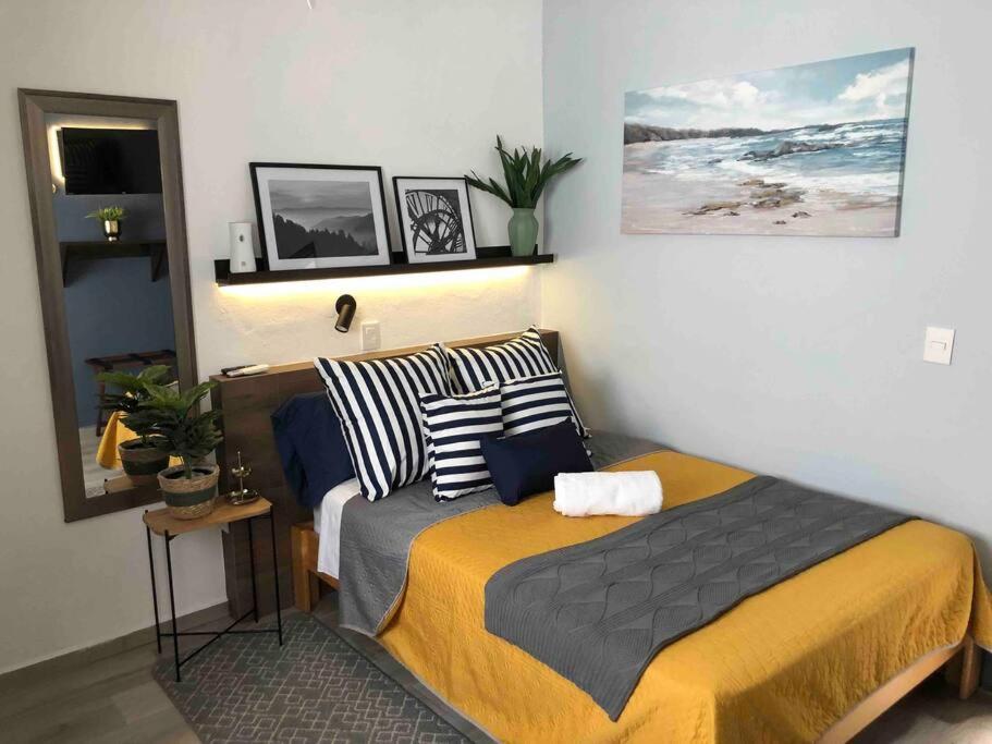 ein Schlafzimmer mit einem Bett und einem Bild an der Wand in der Unterkunft Apartaestudio#7 ITESM aire acondicionado sin cochera in Laborcillas