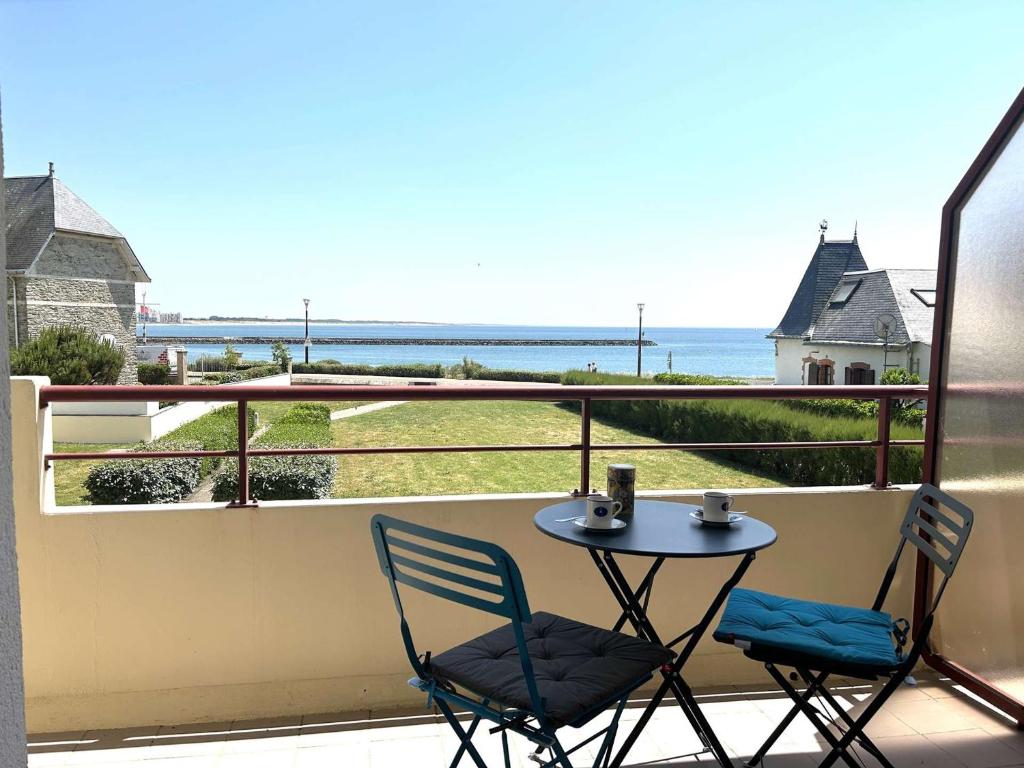 une table et des chaises sur un balcon avec vue sur l'océan dans l'établissement Appartement cosy 2 pièces avec parking à St-Gilles-Croix-de-Vie - FR-1-224-801, à Saint-Gilles-Croix-de-Vie