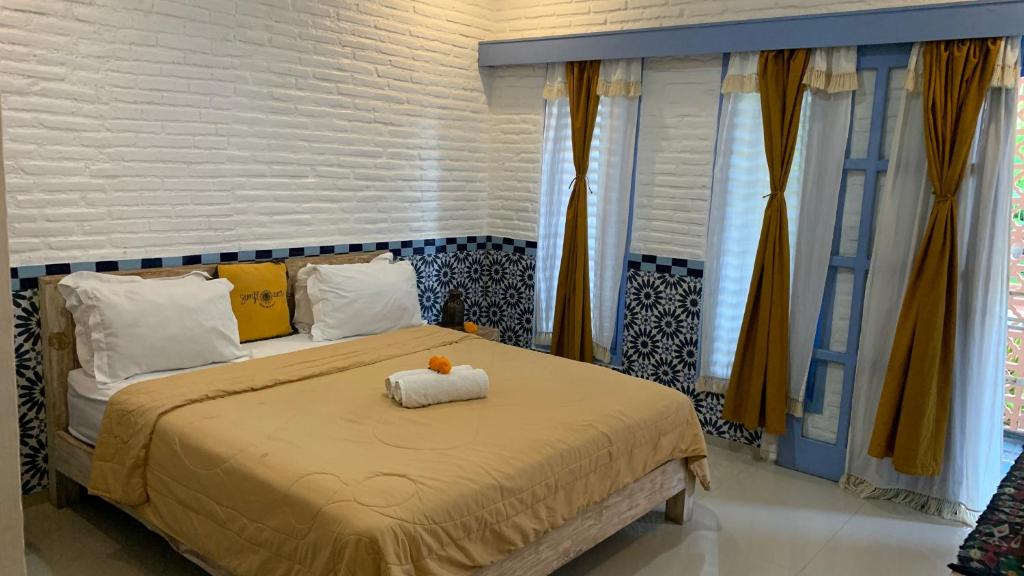 Sunflower Stay And Surf في دينباسار: غرفة نوم بسرير كبير عليها حشره محشوة
