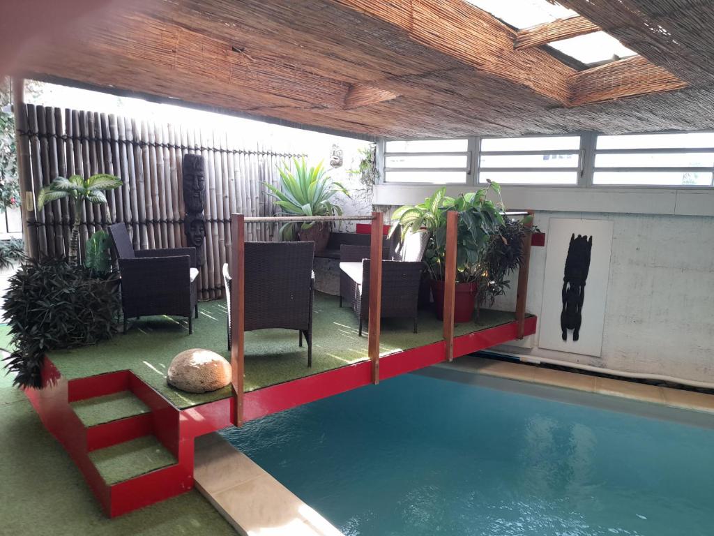 uma casa com piscina, mesa e cadeiras em Alain em Noumea