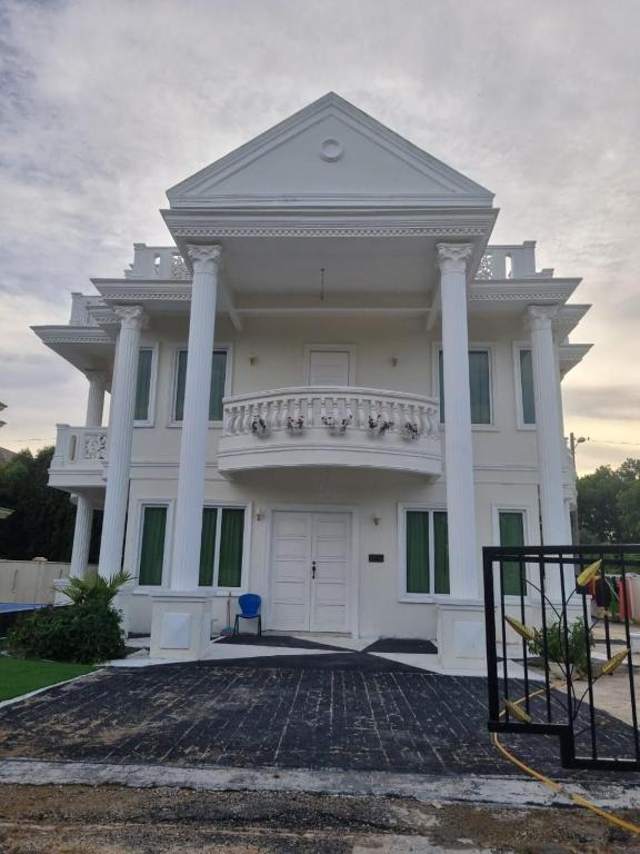 a large white house with columns and a balcony at RoofTop Villa in Malacca