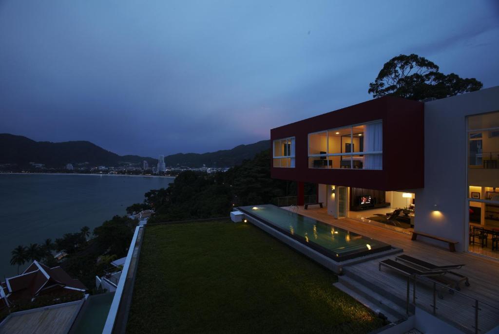 a house with a view of the water at night at Jirana Patong in Patong Beach