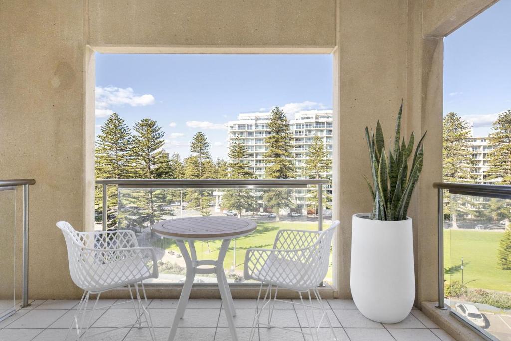 a balcony with a table and chairs and a large window at Belle Escapes - Park View Studio at The Pier in Glenelg