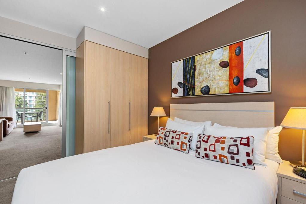 a bedroom with a large white bed and a room at Belle Escapes - Glenelg Seaside Apartment in Glenelg