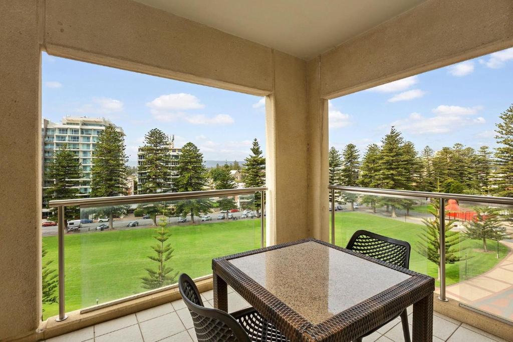 a balcony with a table and chairs and a large window at Belle Escapes - Glenelg Seaside Family Stay in Glenelg