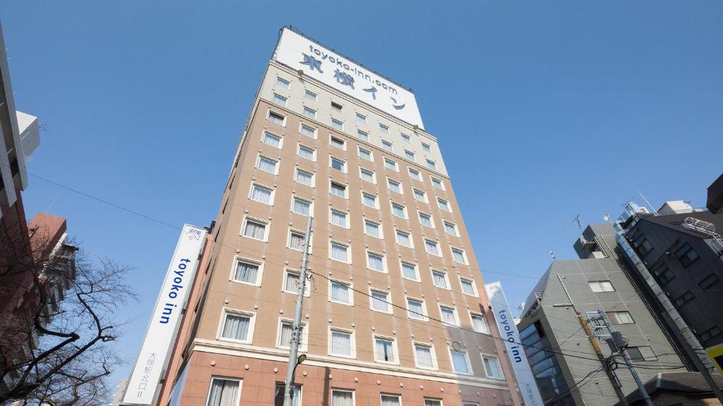 un edificio alto bronceado con un letrero. en Toyoko Inn Tokyo Yamanote sen Otsuka eki Kita guchi No 2, en Tokio