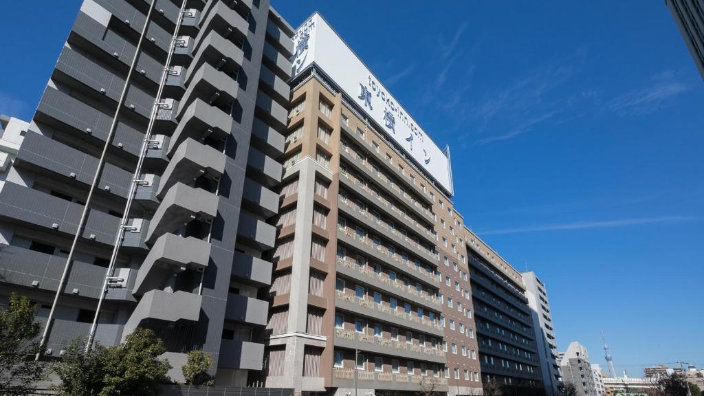 東京的住宿－Toyoko Inn Tokyo Monzen-nakacho Eitaibashi，一座高大的建筑,旁边有一个标志