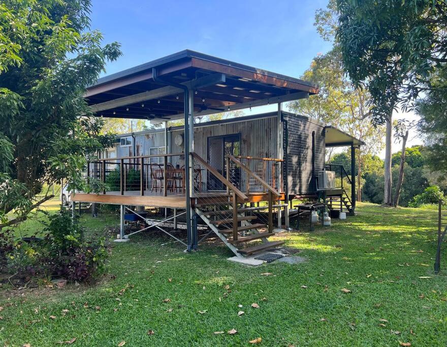 a house with awning on the grass in a field at Hinchinbrook Riverview Retreat in Upper Stone