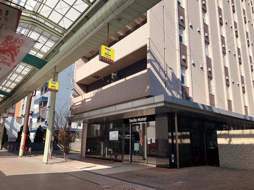 una tienda frente a un edificio con letreros. en Smile Hotel Kokura, en Kitakyushu