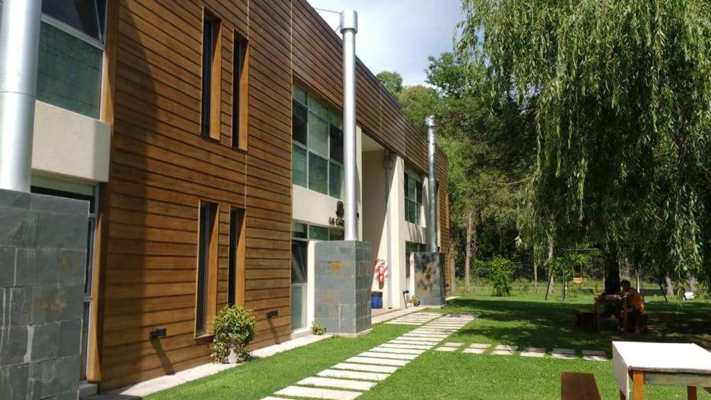 a building with a grass yard in front of it at Las Camelias Apart in Chascomús