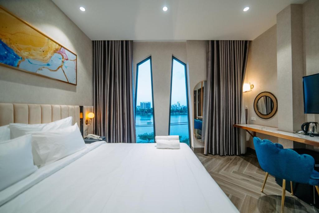 La Beaute Hotel Quy Nhơn في كوي نون: غرفة فندقية بسرير كبير ونافذة