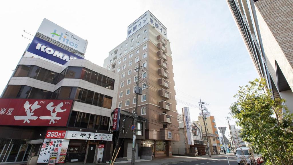 een hoog gebouw op een straat in een stad bij Toyoko Inn Oyama eki Higashi guchi No 1 in Oyama