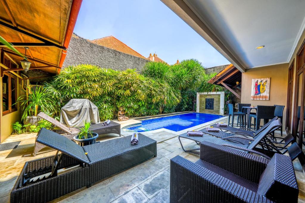 een terras met stoelen en een zwembad bij Villa SANKET - KUTA - 6 bedrooms - 6 bathrooms - Great Location in Kuta