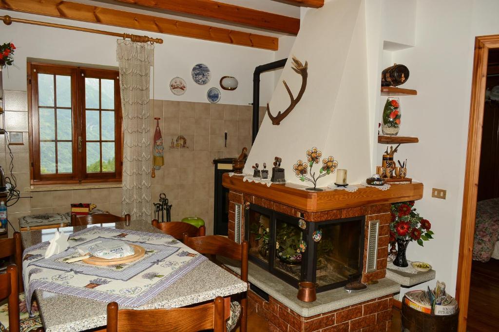 a living room with a fireplace and a dining table at Chalet del paese Incantato in Moncenisio