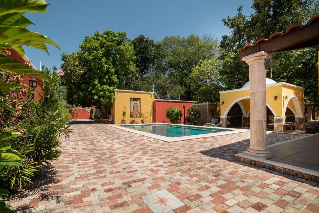 a house with a swimming pool in a yard at Espectacular casona con alberca y jardines in Mérida
