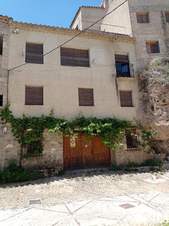 un antiguo edificio de piedra con puerta de madera en Casa Rural Juan, el Zapa, en Letur